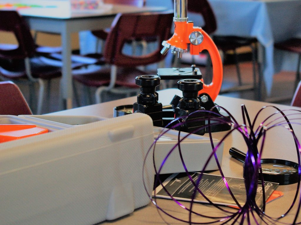 A science classroom setup featuring a microscope, art supplies, and creative materials for children. Educational science classroom with microscope, art supplies, and creative materials.