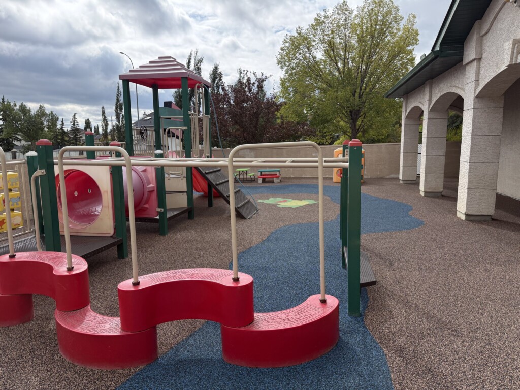 Rooftop play area with climbing equipment near the building archways
