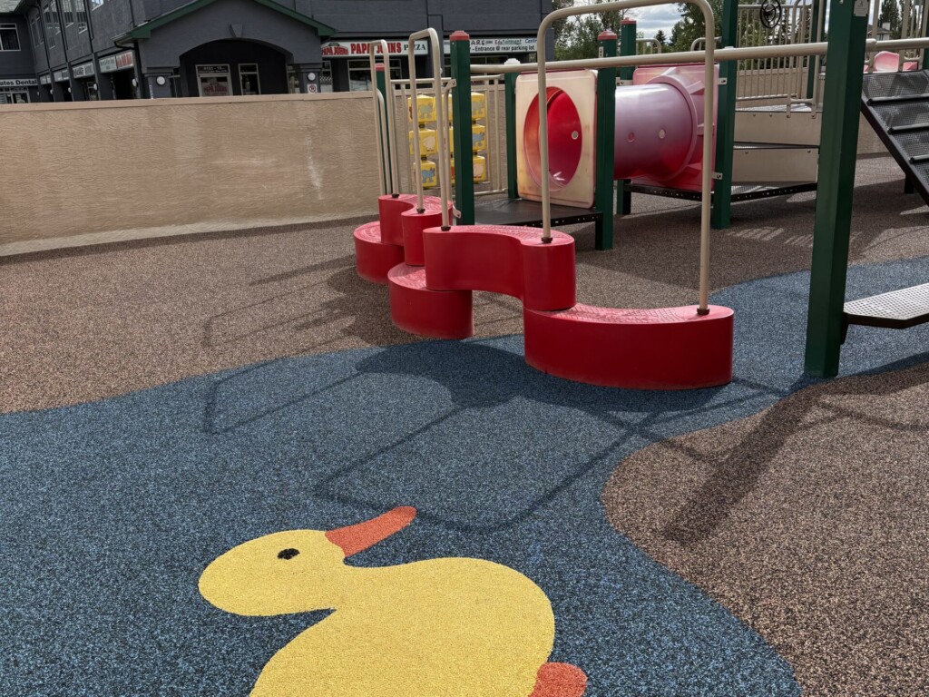Rooftop playground with a duck floor decal and climbing equipment
