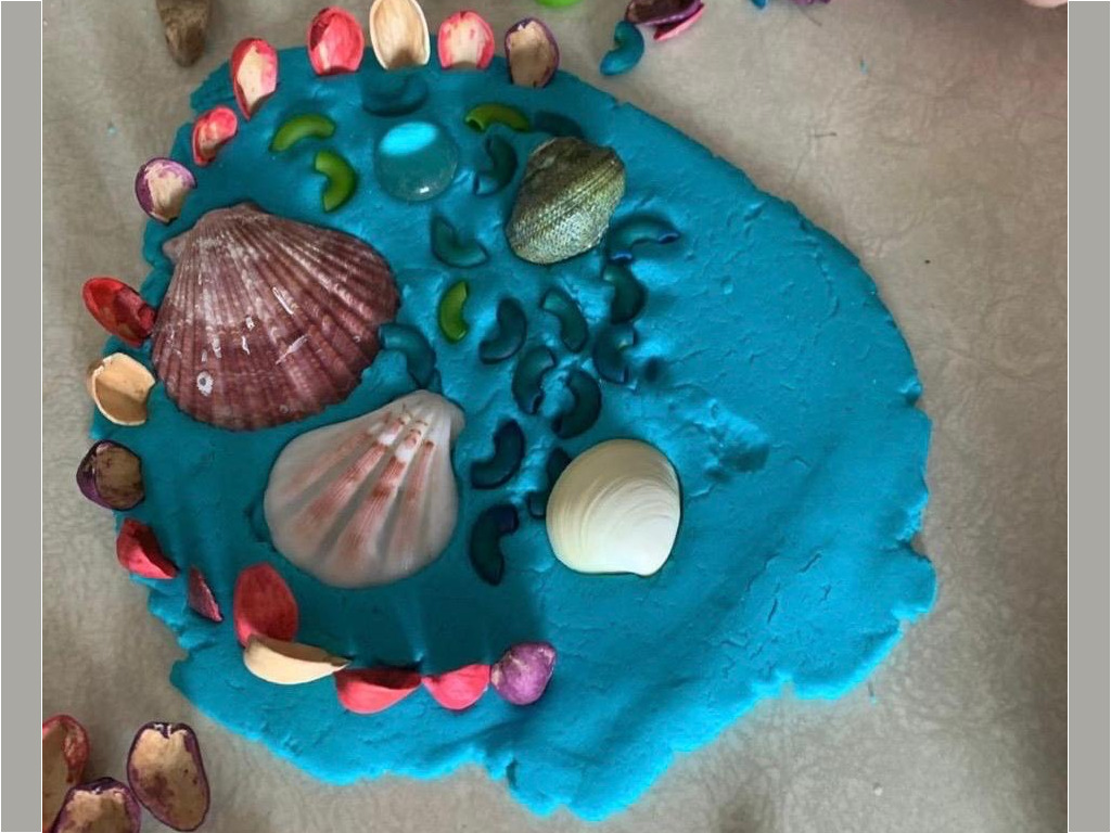 Blue playdough decorated with seashells as a nature sensory craft